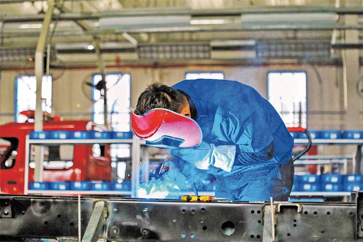 新疆金立新能源车业有限公司的工人在生产车间作业